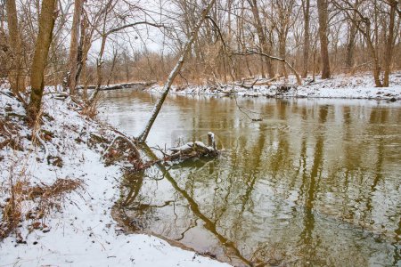 Winter Serenity im Cooks Landing County Park, mit einem ruhigen Fluss, der durch eine schneebedeckte Landschaft in Fort Wayne, Indiana fließt.
