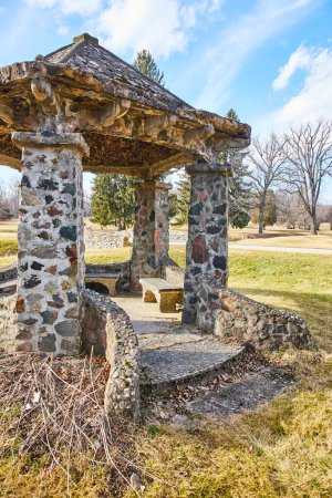 Rustikaler Steinpavillon auf dem ruhigen Lindenwood Cemetery, Fort Wayne, Indiana - ein ruhiges Winterrefugium für Besinnung und Geschichte