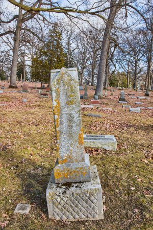 Téléchargez les photos : Pierre tombale aux intempéries debout au milieu d'un cimetière serein dans le cimetière Lindenwood, Fort Wayne, Indiana, sous un ciel d'automne couvert - en image libre de droit