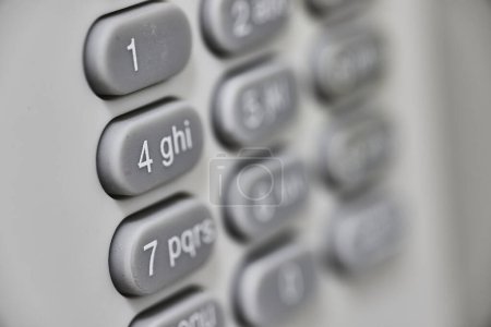 Nahaufnahme einer gut benutzten Zahlentastatur mit Fokus auf 4, die Kommunikation und Sicherheit symbolisiert, aufgenommen in Fort Wayne, Indiana.