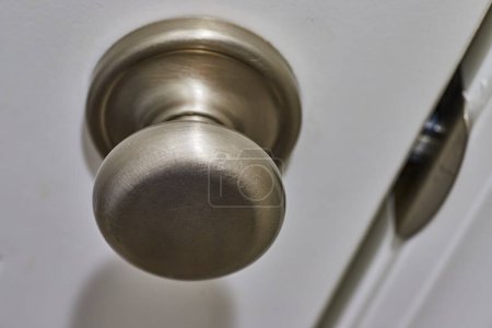 Close-up View of Brushed Metal Doorknob on White Door, Showcasing Texture and Frequent Use, in Fort Wayne, Indiana