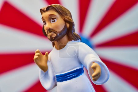 Macro shot of a Jesus figurine in Fort Wayne, Indiana, showcasing spiritual leadership against a vivid sunburst backdrop