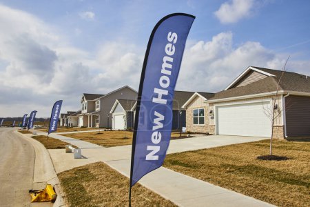 Neu gebaute Häuser in einem pulsierenden Viertel von Fort Wayne, die potenzielle Käufer mit auffälligen New Homes-Bannern einladen.
