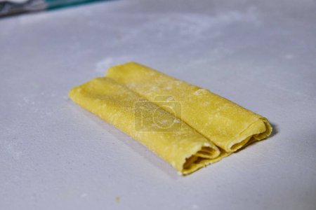 Téléchargez les photos : Pâte à pâtes fraîchement roulée saupoudrée de farine dans une cuisine confortable de Fort Wayne, capturant l'essence de la cuisine italienne maison. - en image libre de droit