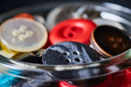 Macro view of a vibrant collection of buttons in a glass jar, capturing creativity and nostalgia in textiles, from Fort Wayne, Indiana.