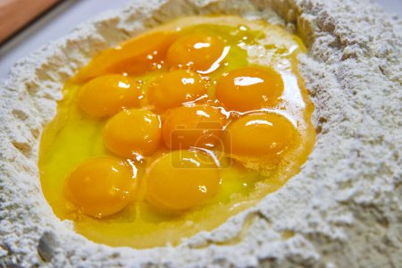 Fresh Indiana eggs nestled in flour, ready for homemade pasta preparation