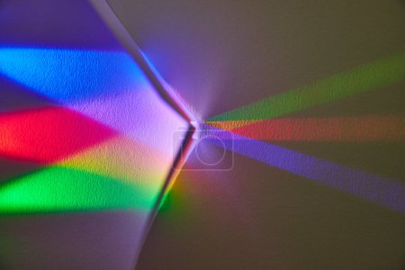 Artistic light dispersion in a room corner, showcasing a vibrant spectrum of colors for an abstract concept of unity and creativity.