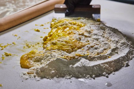 Artisanat culinaire : Gros plan sur la préparation des pâtes à la main dans un environnement de cuisine lumineux à Fort Wayne, Indiana