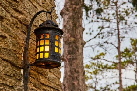 Linterna rústica que proyecta un cálido resplandor en una pared de piedra en el Bishop Simon Brute College, un símbolo atractivo de la historia y la tradición.