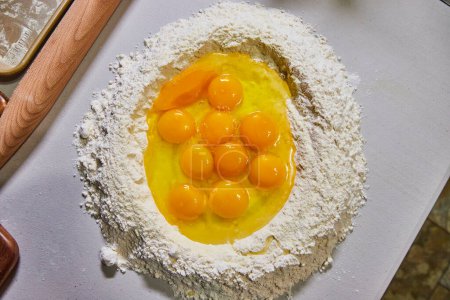 Freshly cracked eggs nestled in flour, ready for homemade pasta making on a cozy Indiana kitchen countertop.
