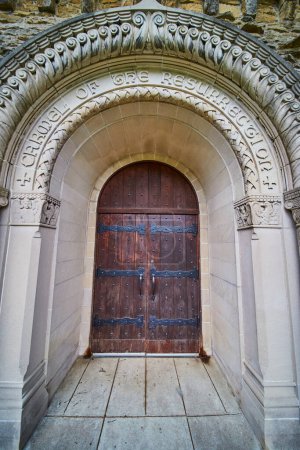 Frühlingstag am Bishop Simon Brute College, der die Erhabenheit gotischer Architektur und christlicher Symbolik an einer historischen Kirchentür zeigt.