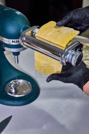 Préparation de pâtes artisanales dans une cuisine professionnelle à Fort Wayne, Indiana, en se concentrant sur le processus de laminage de la pâte avec un mélangeur KitchenAid premium.
