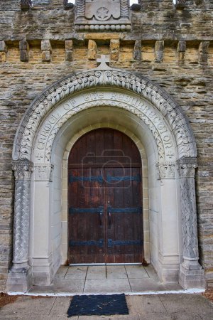 Tagsüber Blick auf den großen, aufwendig geschnitzten Eingang zur historischen Bishop Simon Brute College Chapel in Indianapolis, der zeitlose religiöse Verehrung und architektonische Majestät widerspiegelt.