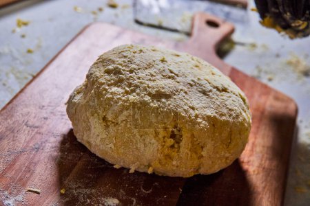 Pâte à pain à grains entiers sur une planche de bois saupoudré de farine, représentant la cuisine maison à Fort Wayne, Indiana.