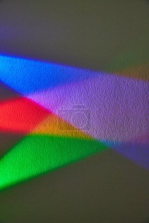 Affichage vibrant de la lumière arc-en-ciel réfractée contre une surface texturée, symbolisant l'unité et la diversité, capturée à Fort Wayne, Indiana.