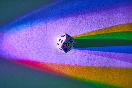 Lebhaft einen Regenbogenschatten werfend, symbolisiert ein 20-seitiger Würfel in dieser abstrakten Makroaufnahme aus Fort Wayne, Indiana, Zufall und Vielfalt..