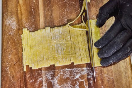 Handgefertigte Pasta-Kunst in Fort Wayne, Indiana - Frisch geschnittene Tagliolini auf rustikalem Schneidbrett.