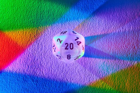 Photo for Vibrant 20-sided dice casting a rainbow spectrum on textured surface, symbolizing diversity, chance, and strategy in Fort Wayne, Indiana. - Royalty Free Image