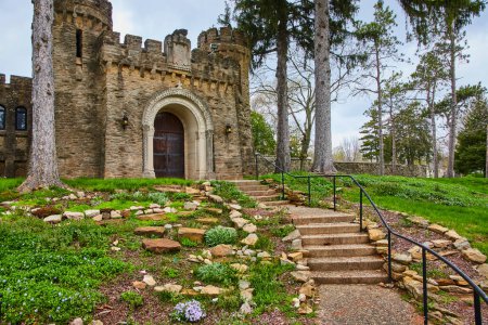 Primavera en el histórico Bishop Simon Brute College en Indianápolis, Indiana. Una atractiva vista de la escalera de piedra rústica que conduce a la gran entrada del castillo medieval.