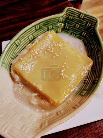 Exotische Mango-Pudding über klebrigem Reis asiatische Nachspeise in einer texturierten grünen Schüssel, serviert in einem Fort Wayne Thai-Café.