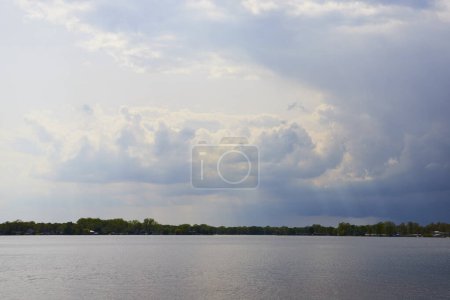 Nuages dramatiques et lac serein au lac Winona, Indiana, allusion à une tempête qui approche.
