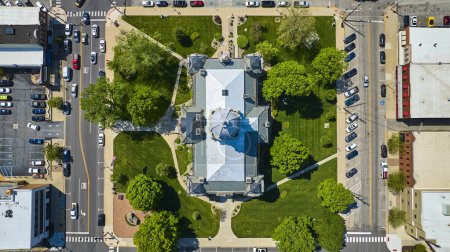 Téléchargez les photos : Vue aérienne du palais de justice du comté de Kosciusko, Indiana, entouré de verdure luxuriante et de routes urbaines animées. - en image libre de droit