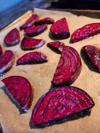 Glistening roasted beetroot slices on a baking sheet, seasoned with salt, embodying home-cooked freshness.