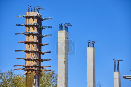 Steigende Betonsäulen unter blauem Himmel, die den Baufortschritt in der Innenstadt von Fort Wayne, Indiana, veranschaulichen.