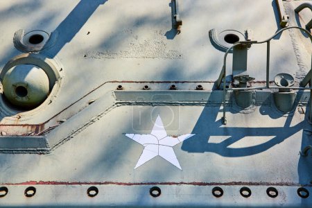 Nahaufnahme eines verwitterten Sternenemblems auf einem Militärpanzer, das Ausdauer und Geschichte symbolisiert.