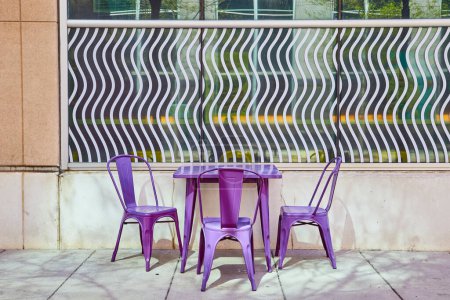 Modernos muebles de exterior púrpura contra una llamativa fachada de vidrio estampado en el centro de Fort Wayne.
