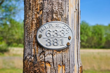 Cartel de utilidad rústico en un poste de madera en Varsovia, Indiana, que simboliza la vida rural americana y la gestión de la tierra.