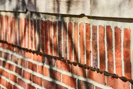 Textured close-up of an aged brick wall in Fort Wayne, showcasing a history of resilience and time.