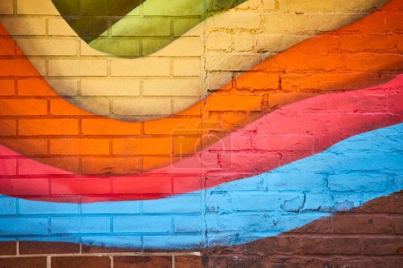 Colorful street art mural on a brick wall in downtown Fort Wayne, blending warm and cool tones.