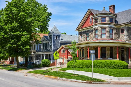 Photo for Charming historic homes line a serene street in Fort Wayne, showcasing diverse architectural elegance under clear skies. - Royalty Free Image