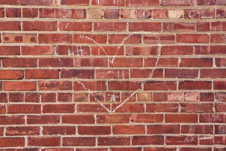 Kreideherz und die Initialen NH auf einer verwitterten Ziegelmauer in der Innenstadt von Fort Wayne, die urbane Liebe symbolisieren.