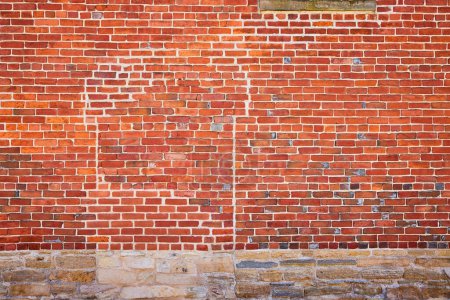 Vivid brick wall with intricate details and natural stone foundation in Fort Wayne, evoking rustic charm and stability.