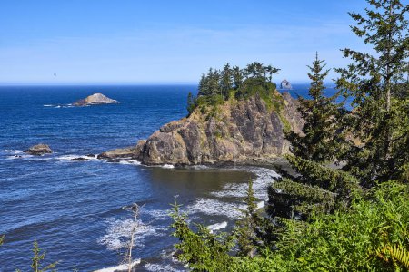 Discover the rugged cliffs, lush greenery, and serene ocean views of Arch Rock in Samuel H. Boardman State Scenic Corridor, Brookings, Oregon. A stunning coastal landscape on the West Coast.