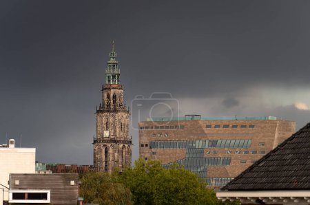 Die Martinitoren und das Forumsgebäude unter dunklem Himmel in der historischen Innenstadt von Groningen.