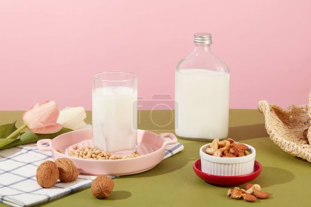 Téléchargez les photos : Concept de vie saine avec du lait de noix dans une tasse et une bouteille non étiquetée. De nombreuses noix et haricots sont affichés. Les noix sont un aliment nutritionnellement riche qui est bon pour la santé - en image libre de droit