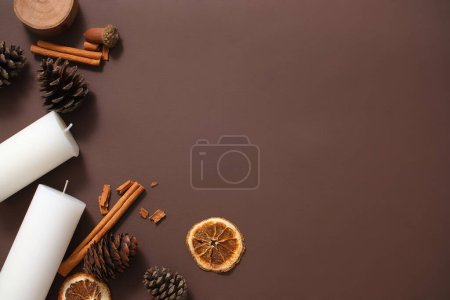 Photo for Minimalist frame of Christmas concept.Top view of dried decorations with white candles on a dark brown background. Blank space for copy of design. Christmas card design ideas - Royalty Free Image