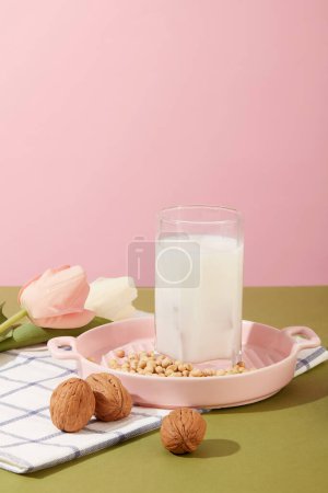 Téléchargez les photos : Peu de noix et de soja sont décorés d'une tasse remplie de lait. Haricots et noix contenant la plupart des vitamines et minéraux dont le corps a besoin - en image libre de droit