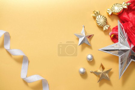 Photo for Xmas background with decorations display on yellow background. Ribbon, baubles and star decorated, create blank space for presentation product and copy space. Top view, flat lay. - Royalty Free Image