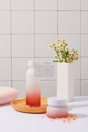Photo for Bathroom concept with a bottle and jar decorated with pink towel and a pot of flowers. Pink himalayan salt contains a whopping 84 different minerals - Royalty Free Image