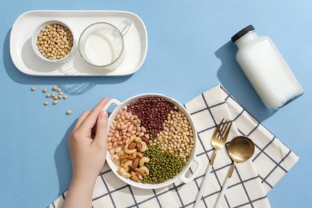 Photo for Many types of nuts and beans are contained inside a dish. Empty label bottle and a cup filled with milk. Nuts and beans have been shown to promote weight loss - Royalty Free Image