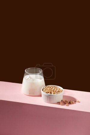 Foto de Escena mínima de una taza de leche fresca decorada con mucha soja dentro de un tazón blanco. Las nueces son una gran fuente de varios nutrientes, incluida la vitamina E. - Imagen libre de derechos