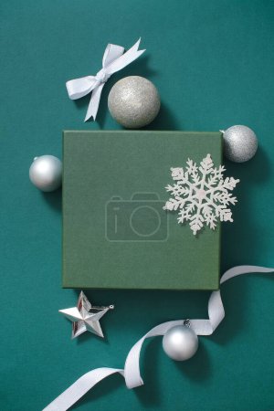 Foto de Fondo verde simple pero extremadamente hermoso con concepto de decoración navideña. Destacan las bolas, cintas y copos de nieve de color plata. Espacio en blanco para el producto de visualización - Imagen libre de derechos