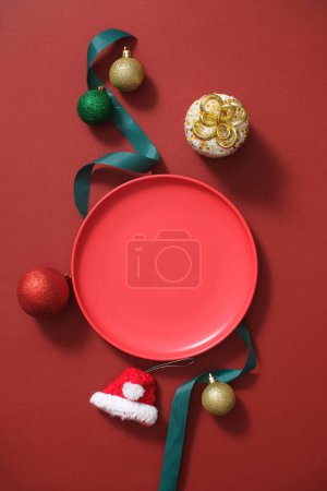 Foto de Ideas creativas para productos publicitarios en vacaciones de Navidad. Algunas decoraciones con placa de cerámica redonda se muestran sobre un fondo rojo. Espacio en blanco para mostrar productos cosméticos - Imagen libre de derechos