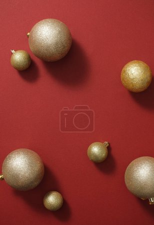 Foto de Las brillantes bolas doradas están dispuestas aleatoriamente sobre un fondo rojo. Espacio vacío para la presentación de productos cosméticos y espacio de copia. Vista superior - Imagen libre de derechos