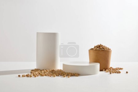 Téléchargez les photos : Cylindre et podiums ronds disposés avec un bol en bois de soja. Les formes géométriques podium pour l'affichage des produits. Le soja peut être ajouté aux produits de soins de la peau - en image libre de droit