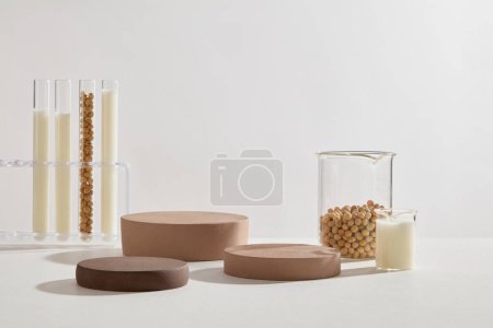 Photo for Podiums in brown color decorated with few beakers and test tubes filled with soybean milk and soybean seeds. Minimal podium display for cosmetic product presentation - Royalty Free Image